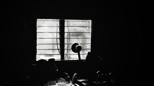 Silhouette people on table against window