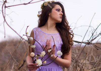 Portrait of beautiful young woman standing against wall