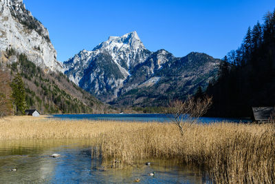 Scenic view of lake by mountains against clear sky