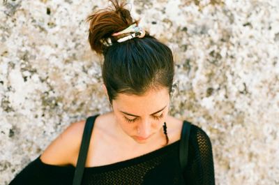 Close-up of young woman standing against wall