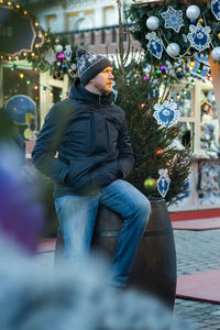 Portrait of young woman standing by christmas tree