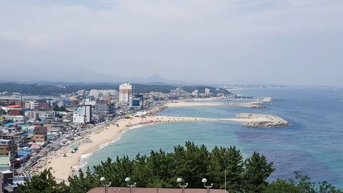 Scenic view of sea by city against sky