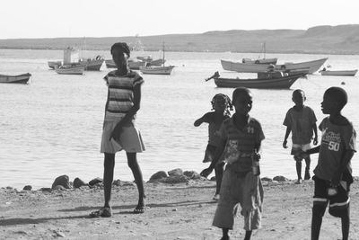 Rear view of people standing on beach