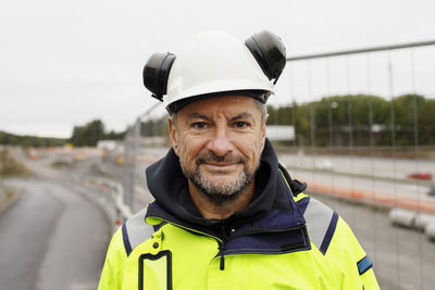 Portrait of male engineer in reflecting clothing at building site