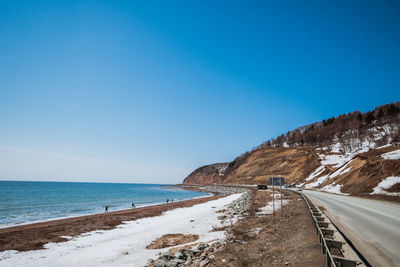 Scenic view of beach against clear blue sky