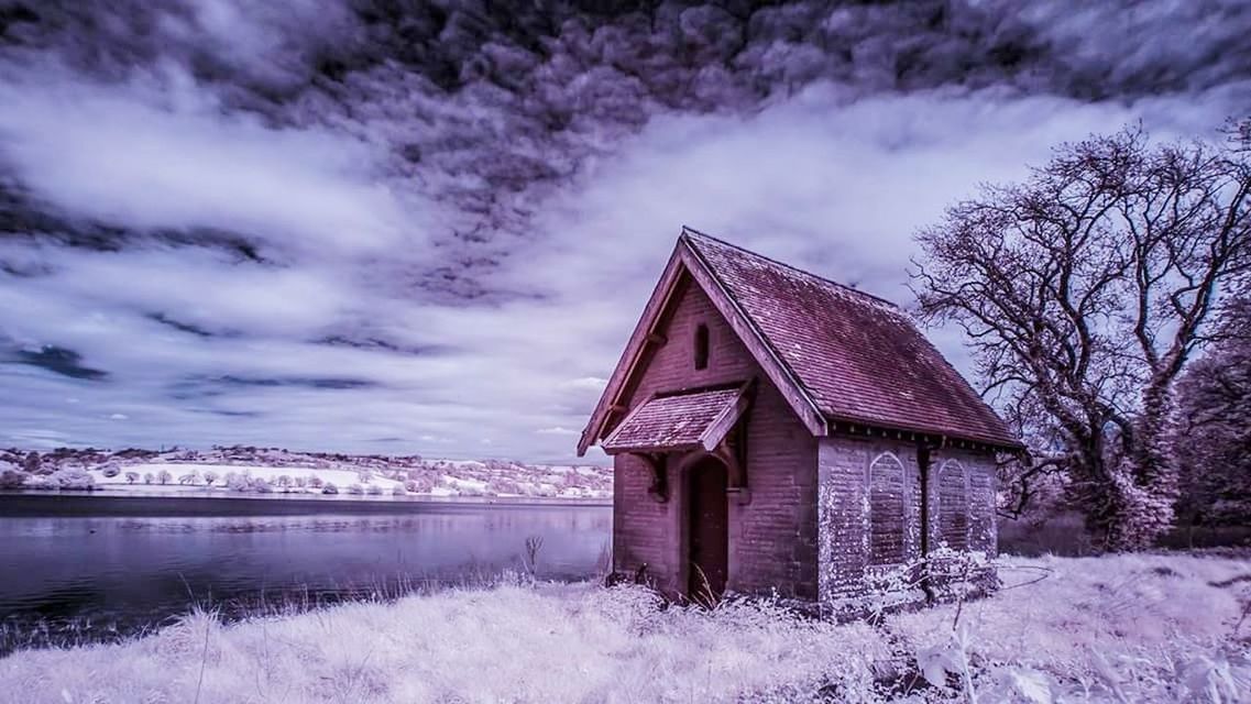 BUILT STRUCTURE ON RIVER AGAINST SKY