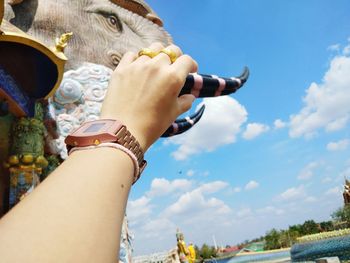 Midsection of woman holding hands against sky