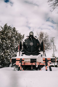 Train on snow covered landscape against sky