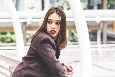 Young businesswoman standing on elevated walkway 