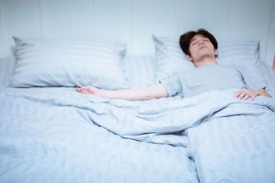 Young woman sleeping on bed at home