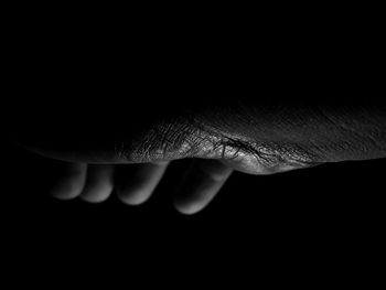 Close-up of hand over black background