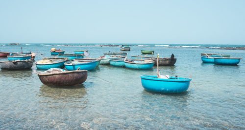 Boats moored on sea against clear sky