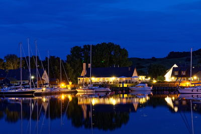 Boats moored in harbor at night