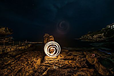 View of fire swirl on beach at night