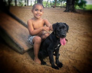 Portrait of smiling woman with dog sitting outdoors