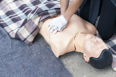 Midsection of paramedic performing cpr on mannequin