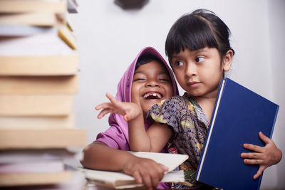 Portrait of a smiling young woman reading book