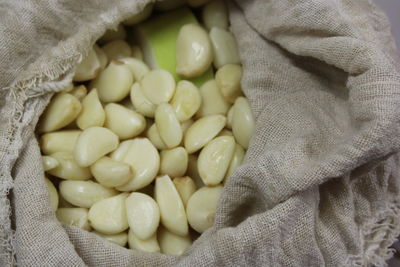 Close-up of garlics in sack
