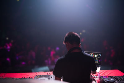 Rear view of man playing music on sound mixer