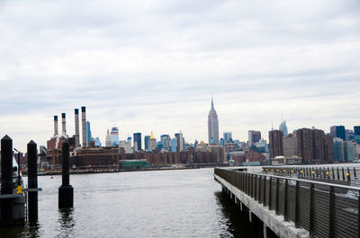 View of buildings at waterfront against cloudy sky