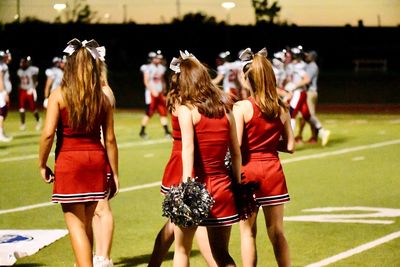 Rear view of cheerleaders on football stadium