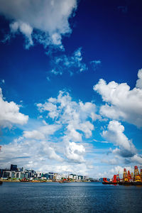 Scenic view of river by buildings against sky