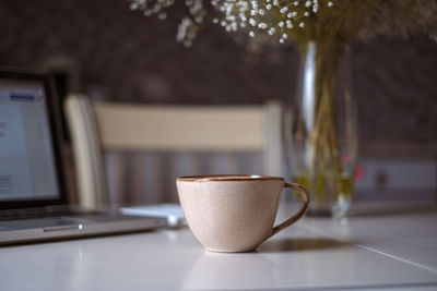 Close-up of coffee cup on table at home