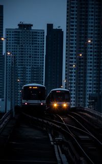 Cars on illuminated street in city at night