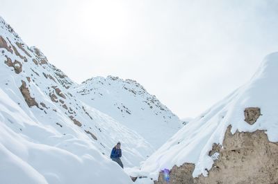 Man on snowcapped mountain against sky