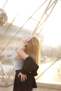 Low angle view of woman standing by window