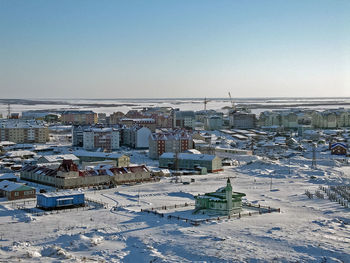 High angle view of townscape against snow covered landscape