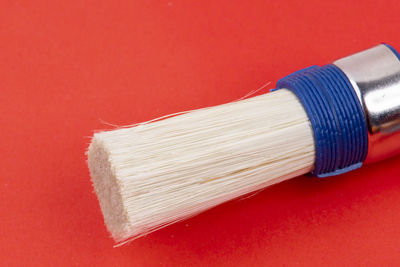 Close-up of paintbrushes against red background