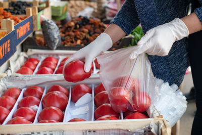 Shopping in the context of a coronavirus pandemic. a woman in disposable gloves buys vegetables