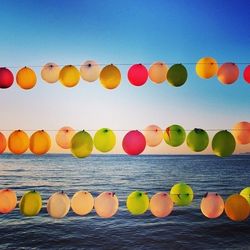 Colorful balloons hanging against blue sky