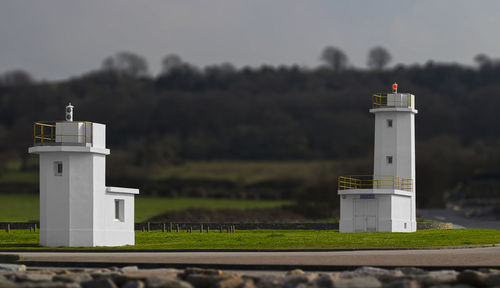 Lighthouse on field against sky