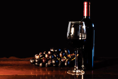 Close-up of wine with grapes on table