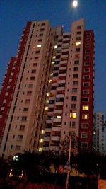 Low angle view of modern building against blue sky at night