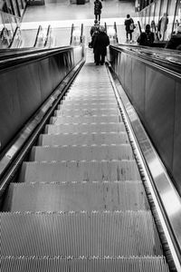 Rear view of people walking on escalator