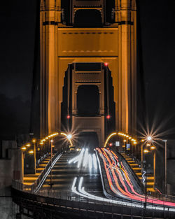 Light trails on bridge in city at night