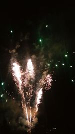 Low angle view of fireworks against sky at night