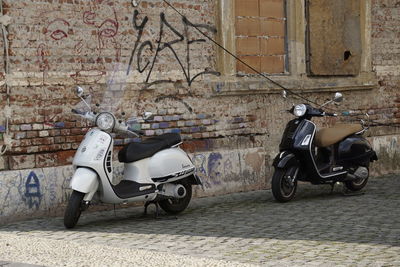 Bicycles parked on street against wall