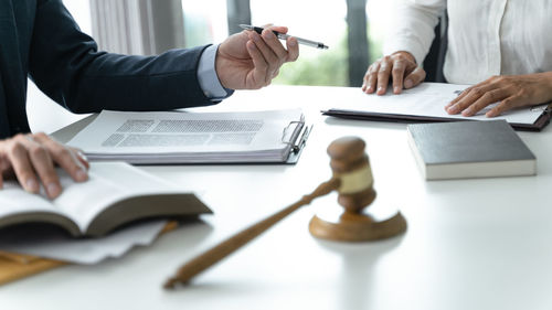 Midsection of business colleagues working on table