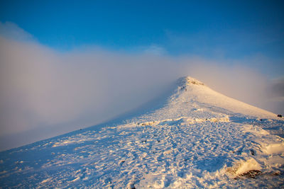 Aerial view of snowcapped mountain against sky