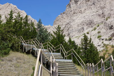 Stairs leading towards mountain against clear sky