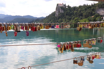 View of padlocks on river against mountains