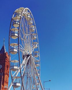 Low angle view of ferris wheel against blue sky in summer in cardiff bay wales united kingdom