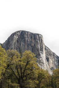 Low angle view of rocks on mountain against clear sky