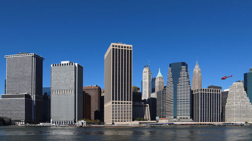 Modern buildings in city against clear blue sky