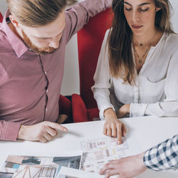 Young couple discussing over document while real estate agent explaining 