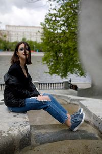 Portrait of young woman sitting on rock